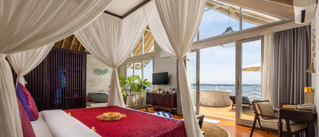 Luxurious bedroom with a four-poster bed, private pool, and stunning sea views in Nusa Penida.