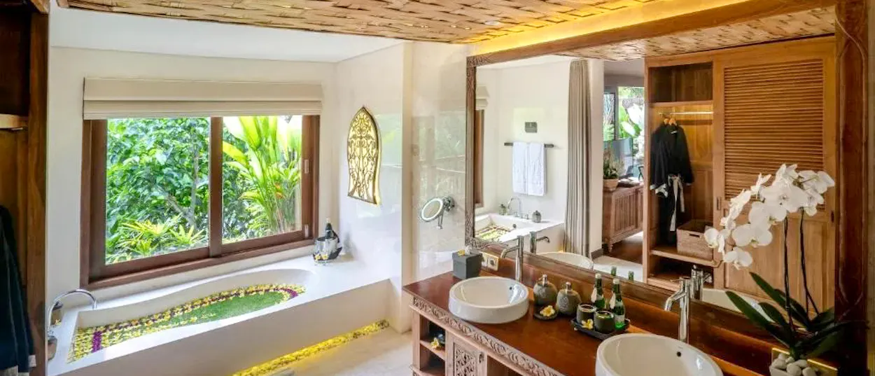 Elegant bathroom at The Kayon Jungle Resort, Ubud, featuring a flower bath and lush jungle scenery.