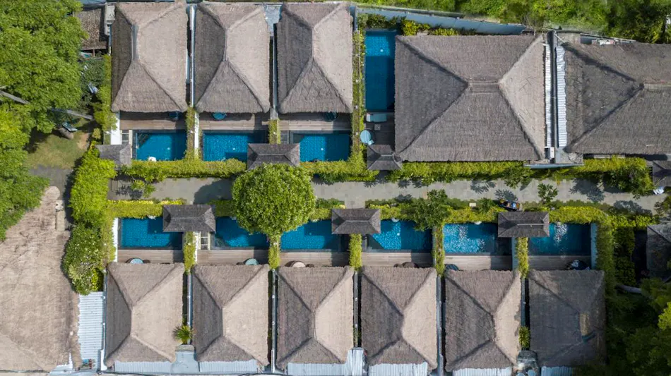 Aerial view of Lembongan Beach Club & Resort, featuring thatched-roof villas, private pools, and lush gardens.
