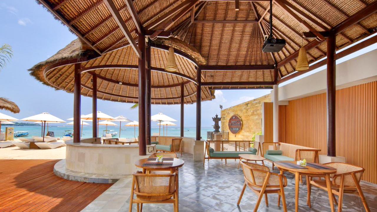 Lembongan Beach Club restaurant with thatched roofs, wicker furniture, and ocean views.