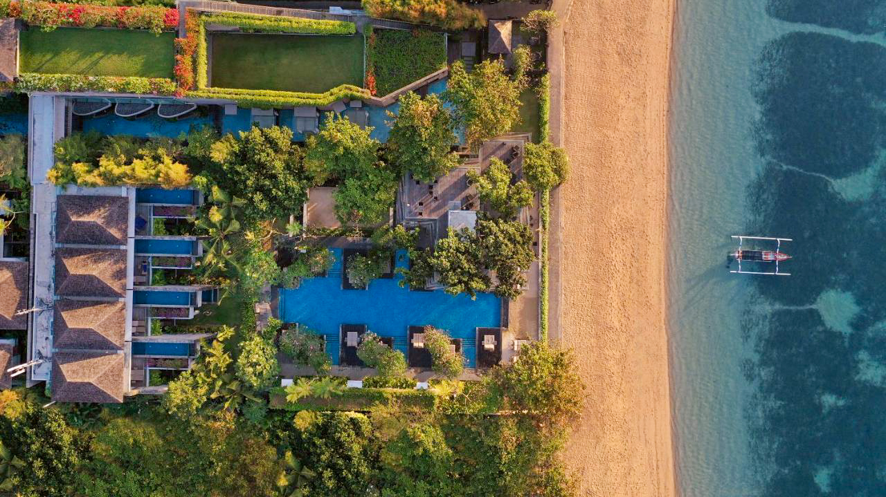 Luxurious tropical resort with pools, gardens, and a sandy beach in Sanur, Bali.