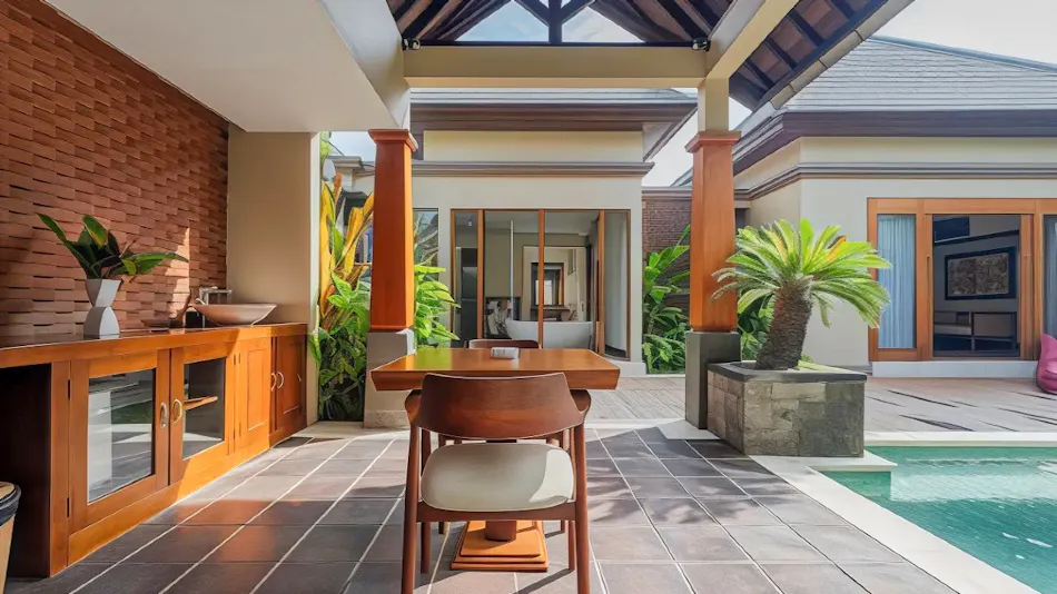 Luxurious outdoor patio with a dining table, sink, and swimming pool at a Bali resort.