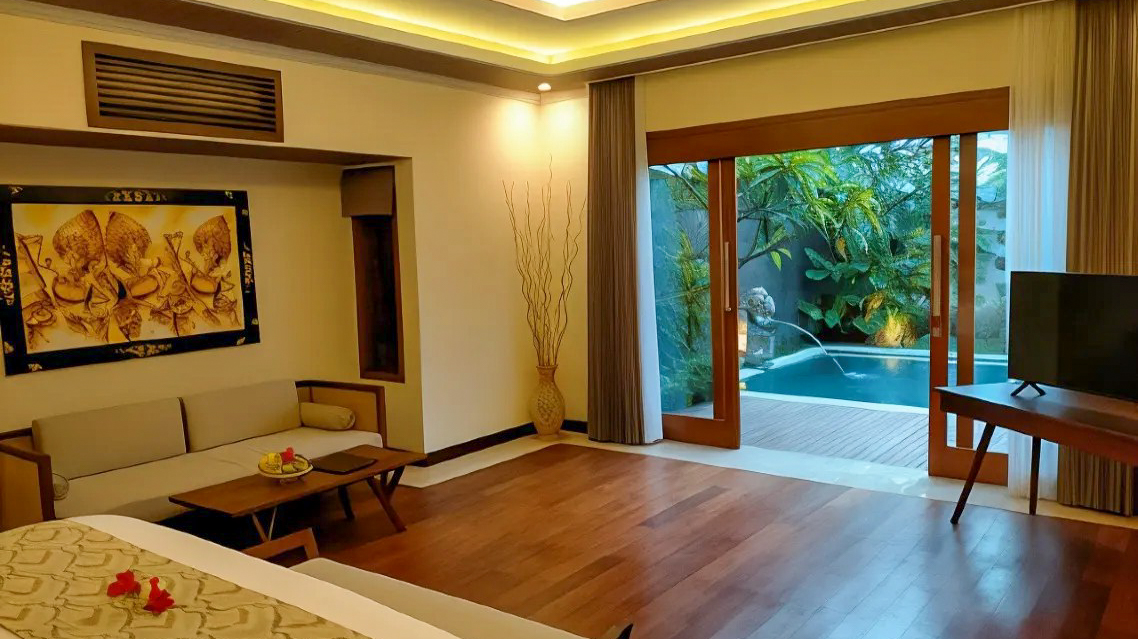 Spacious resort room with a comfortable sofa, artwork, and private pool access in Bali.