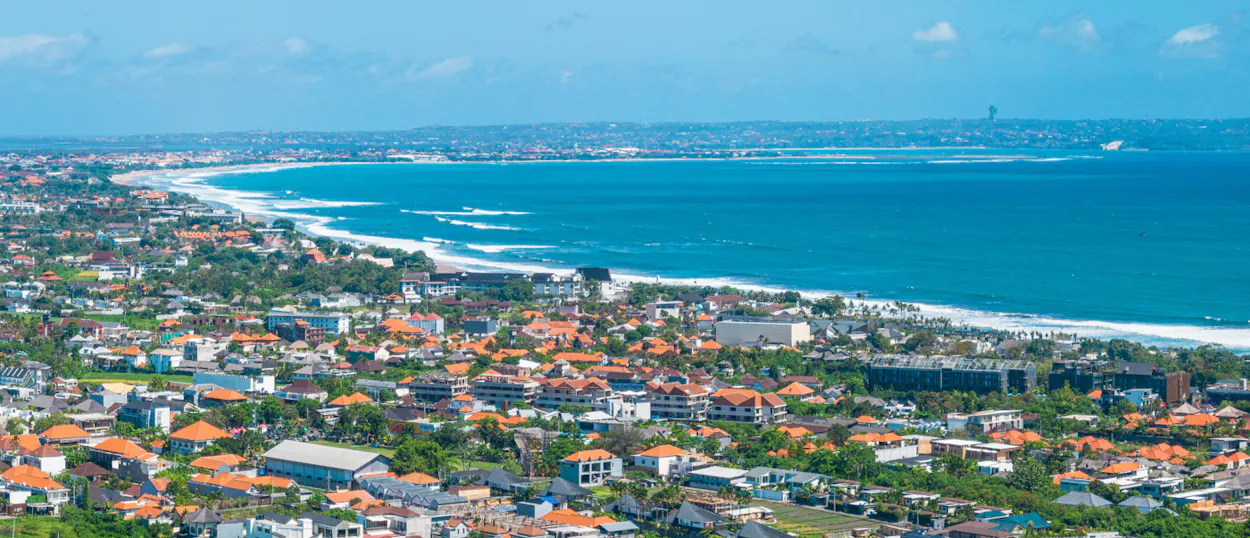 Vibrant coastal town of Seminyak, Bali, with a long sandy beach and sparkling blue ocean.