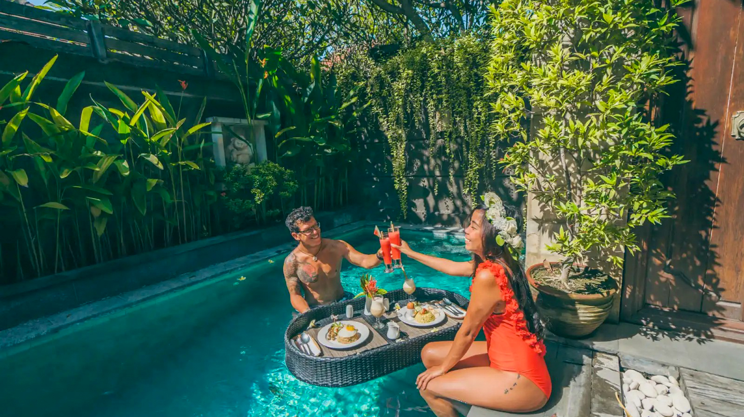 A couple enjoying a romantic floating breakfast in a private pool in Bali.