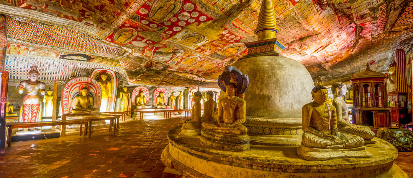 Ancient Buddha statues and colorful murals adorn the sacred Dambulla Cave Temple in Sri Lanka.