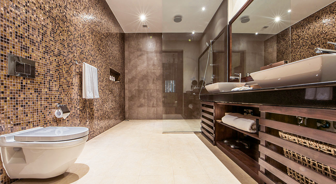 Elegant hotel bathroom in Colombo with warm mosaic tiles, a spacious vanity, and a modern glass shower.