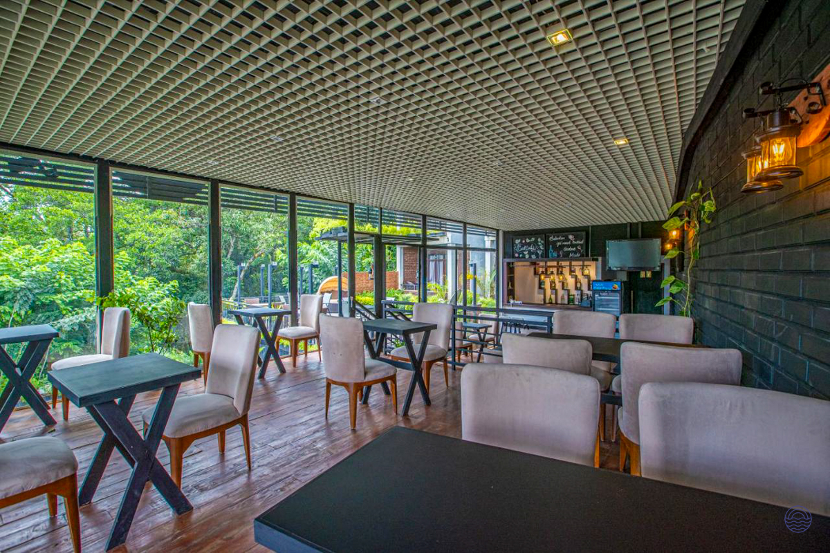 Modern restaurant with comfortable seating and large windows offering a lush green view in Ella.