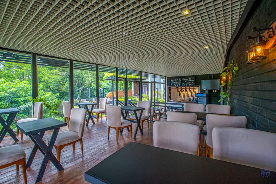Modern restaurant with comfortable seating and large windows offering a lush green view in Ella.