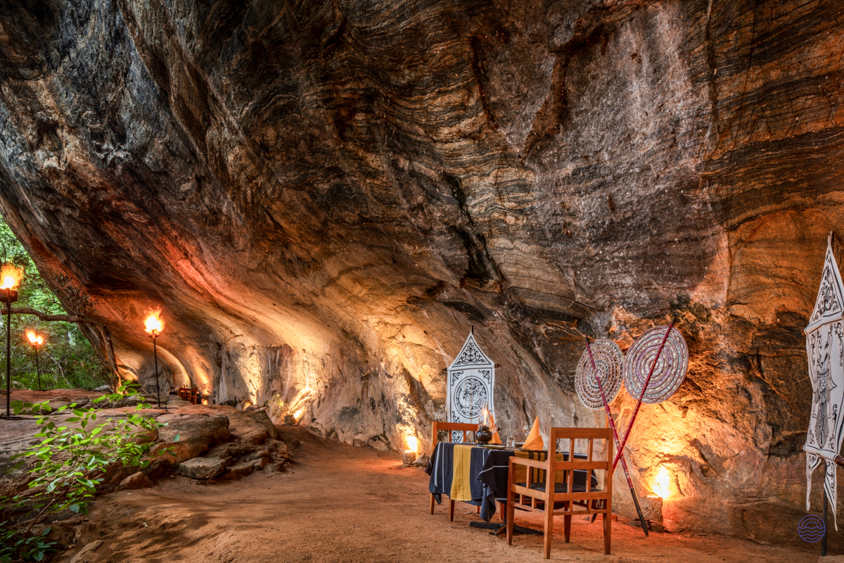 Romantic cave dining experience with warm lanterns illuminating a table for two in Sigiriya, Sri Lanka.