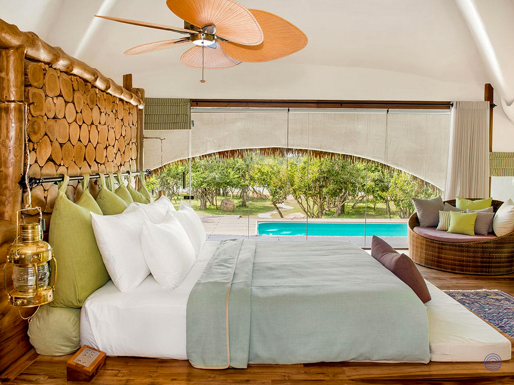 Luxurious bedroom in Yala National Park, featuring a comfortable bed and a view of a private pool.