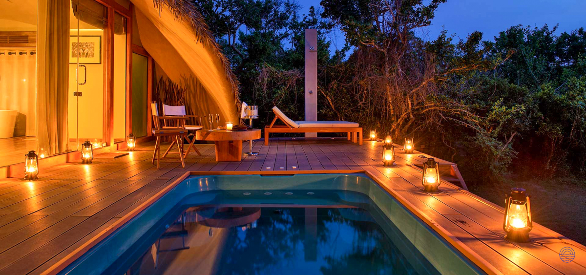 A luxurious private plunge pool and patio, illuminated by lanterns, at Uga Chena Huts, Yala.