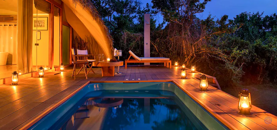 Luxury cabin with private plunge pool and deck, illuminated by warm lanterns at Yala Uga Chena Huts.
