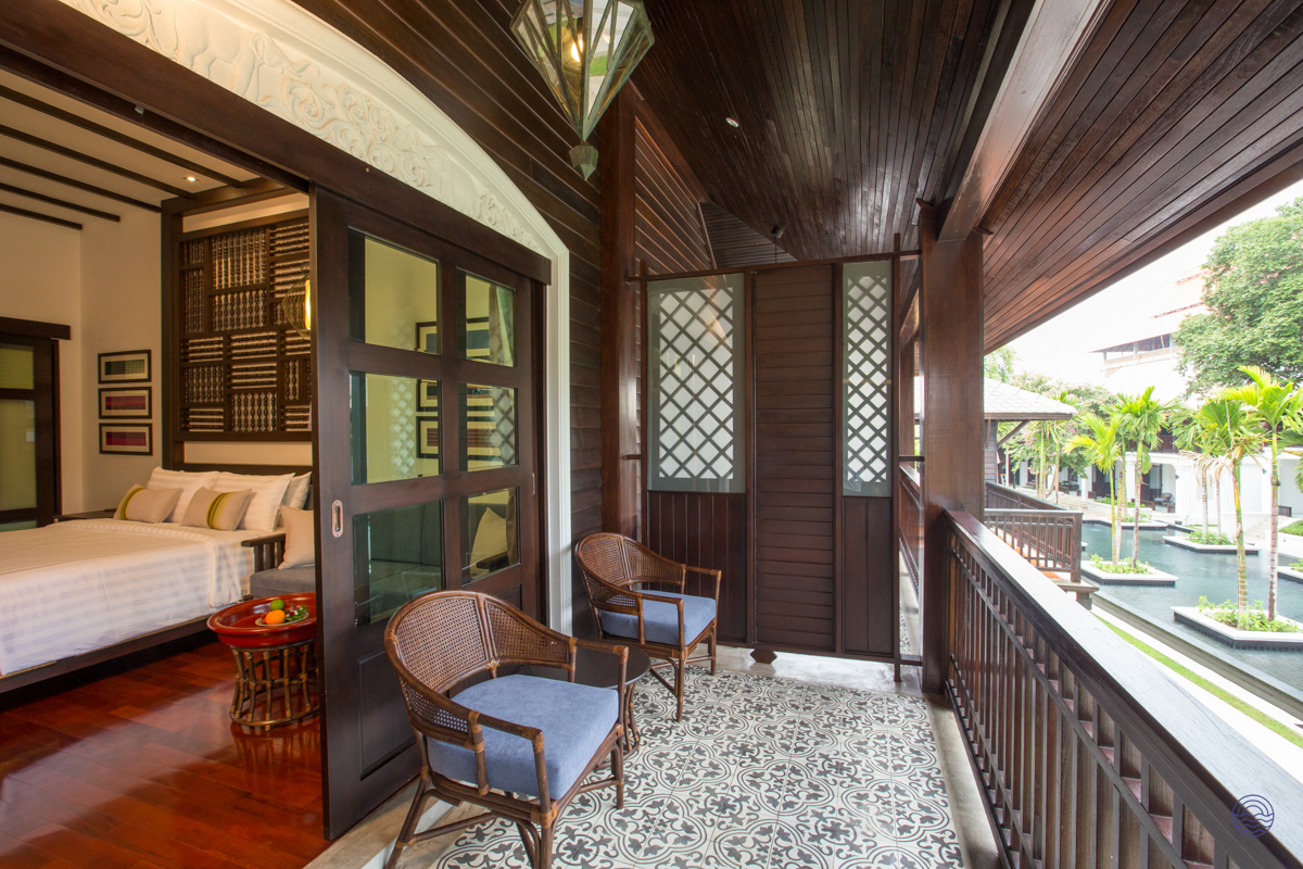 A private balcony with two chairs overlooking a serene pool at a luxurious resort in Chiang Mai.