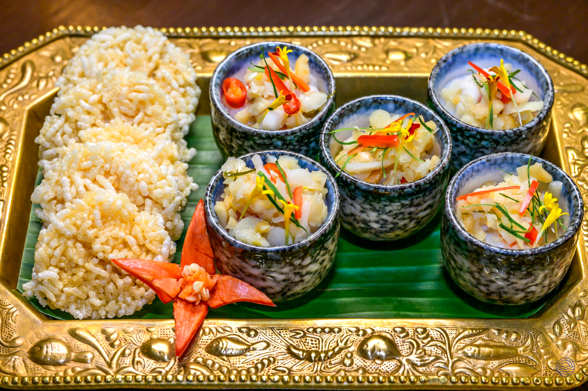 Elegant Thai appetizers and crispy rice cakes beautifully presented on a golden tray in Bangkok.