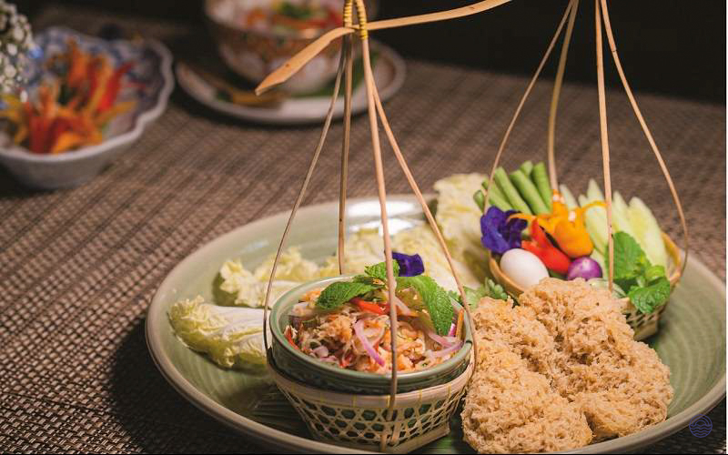 Beautifully presented authentic Thai dinner in Bangkok, with fresh vegetables, crispy fish, and a flavorful salad.