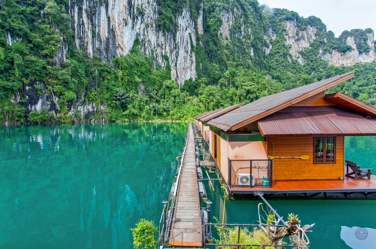 Scenic floating bungalows on the tranquil turquoise lake surrounded by dramatic limestone cliffs in Khao Sok.