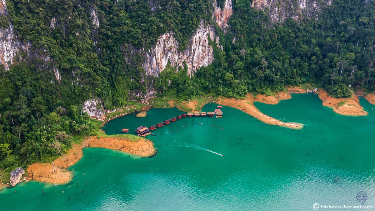 Tranquil floating bungalows on turquoise Chiewlan Lake, surrounded by majestic green cliffs in Khao Sok.