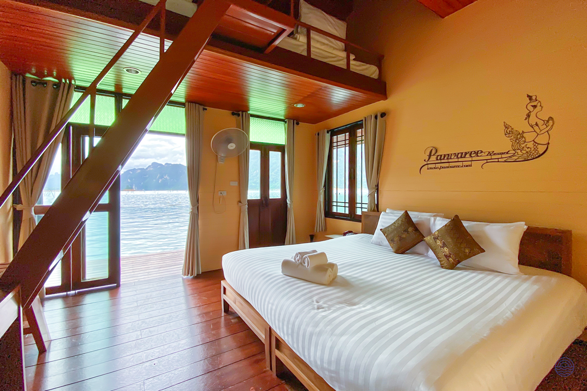 A comfortable floating bungalow bedroom with a loft overlooking the serene Chiewlan Lake in Khao Sok.