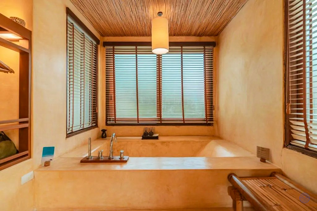 Relaxing bathroom in a Koh Kood villa, featuring a large built-in tub and natural wood accents.