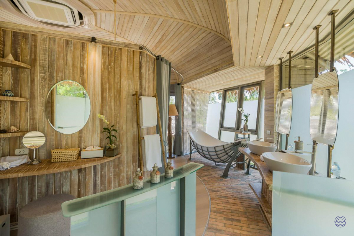 Luxurious tree house villa bathroom with natural wood walls, twin sinks, and a relaxing hammock.