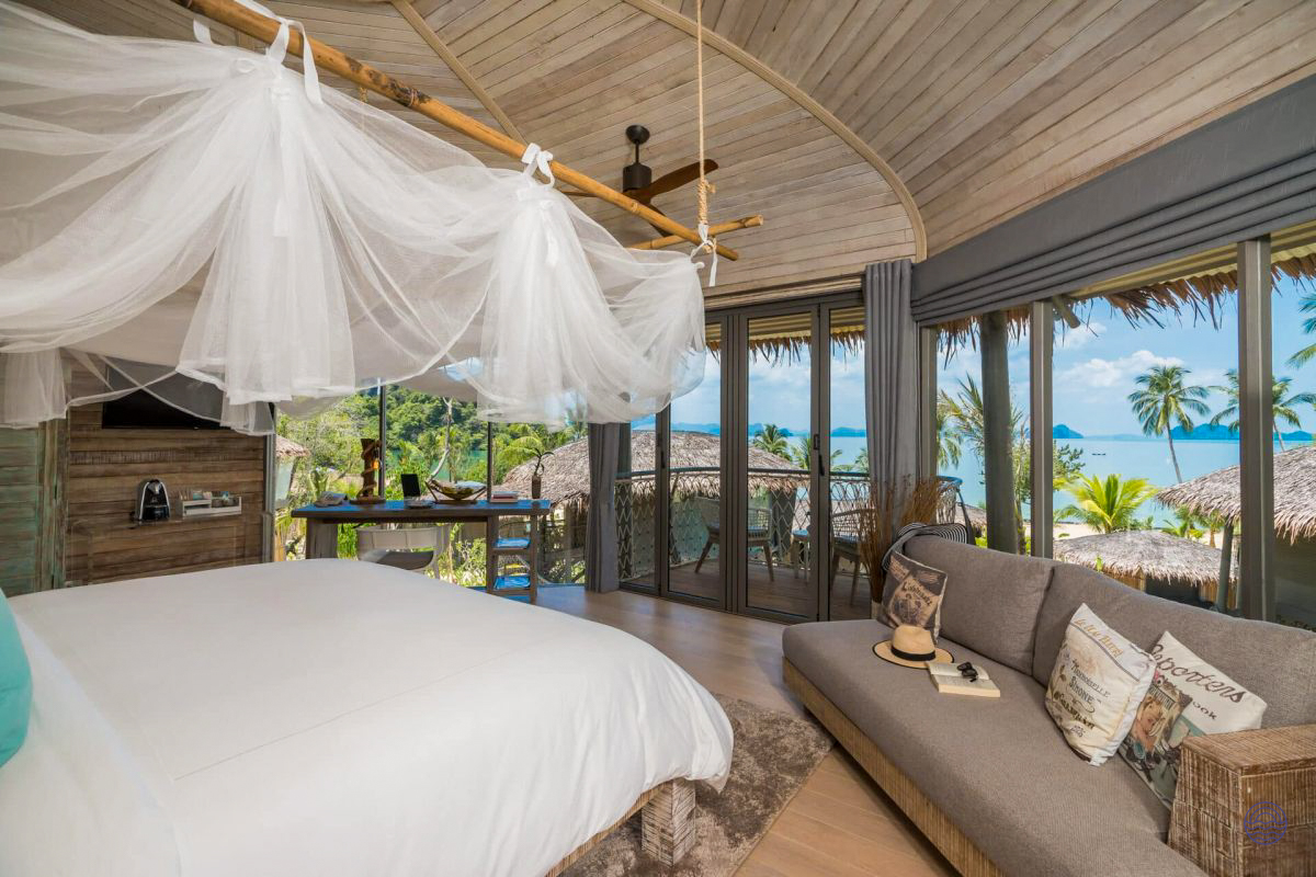 Luxurious tree house villa bedroom on Koh Yao Noi, featuring a canopy bed and stunning ocean views.