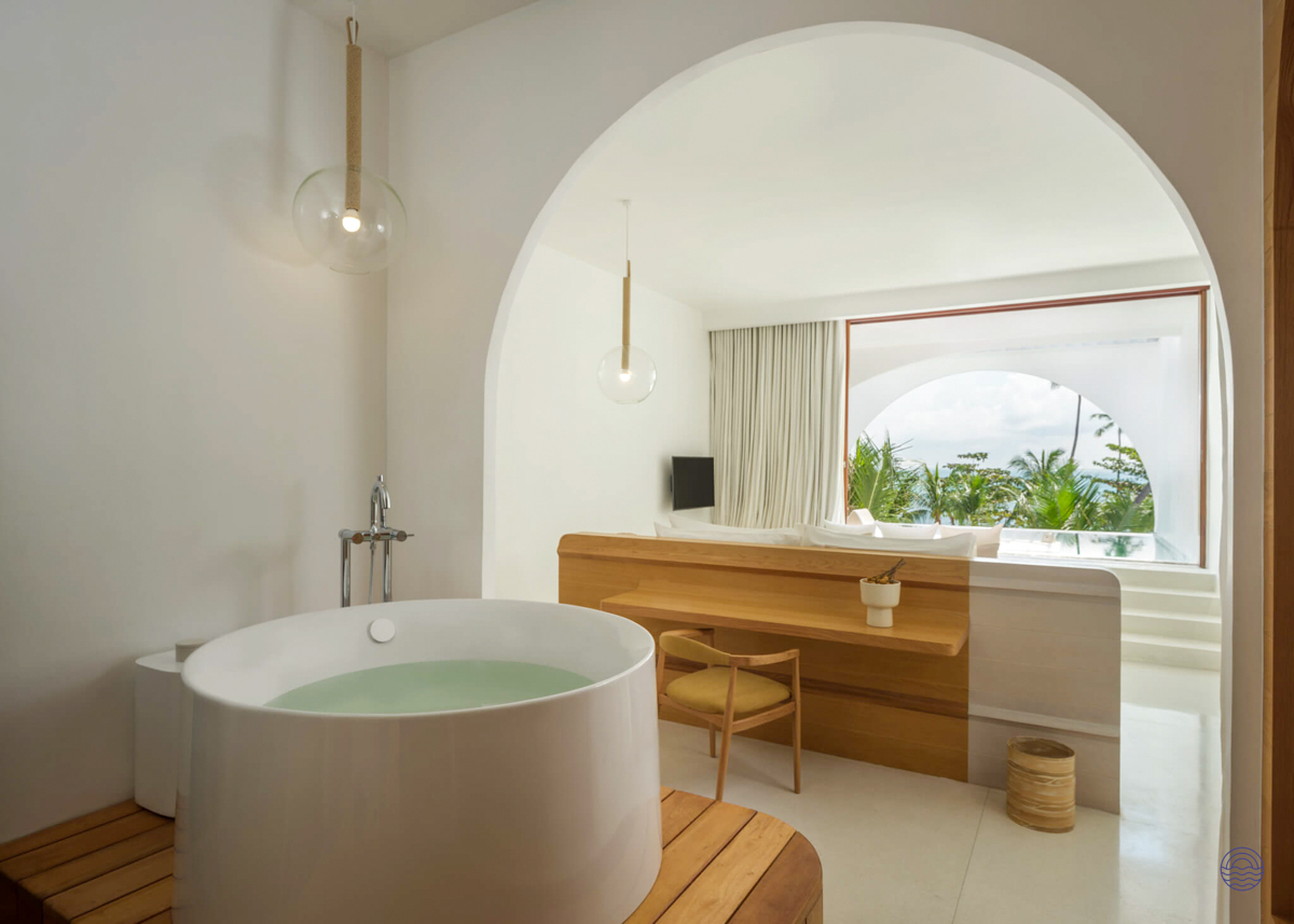 Luxurious white bathroom with a round tub and tropical ocean view from a resort in Koh Samui.