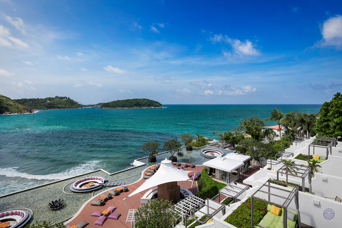 Stunning ocean views from a luxurious beachfront resort in Phuket, with elegant pools and lounge areas.