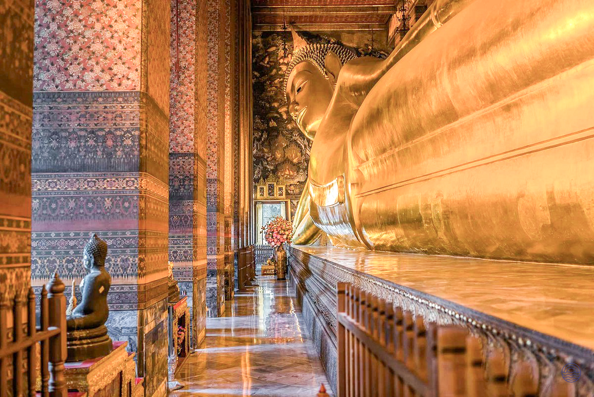 The magnificent golden reclining Buddha statue gleams within the ornate Wat Pho temple in Bangkok.