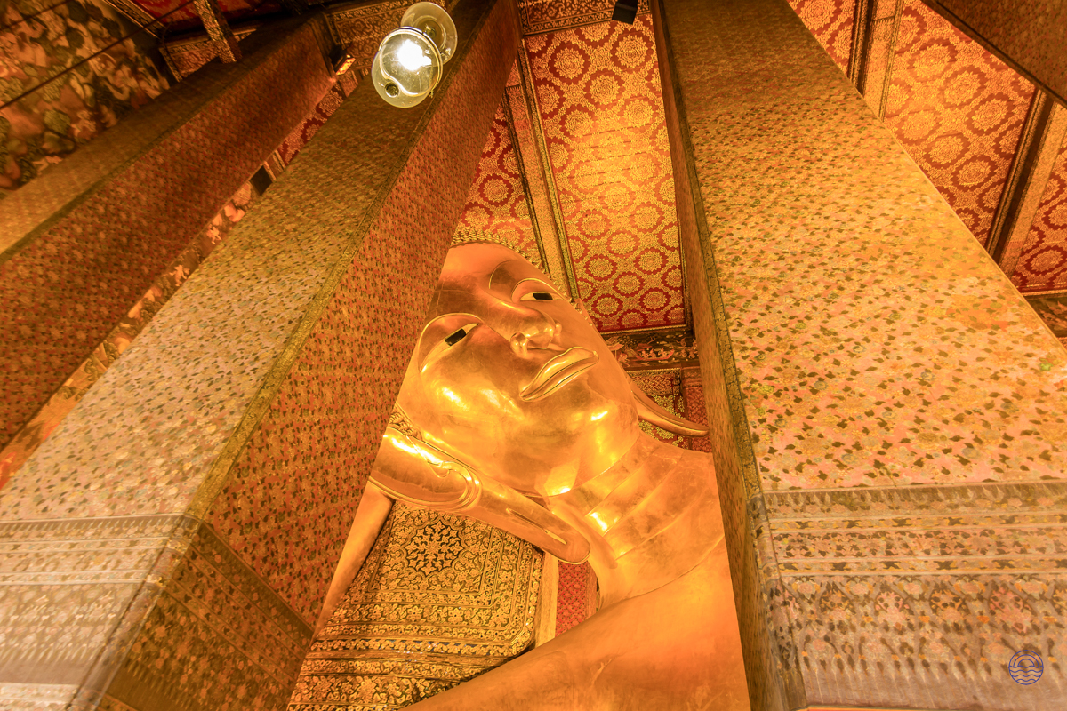 The magnificent golden reclining buddha statue at Wat Pho temple in Bangkok, a truly iconic sight.