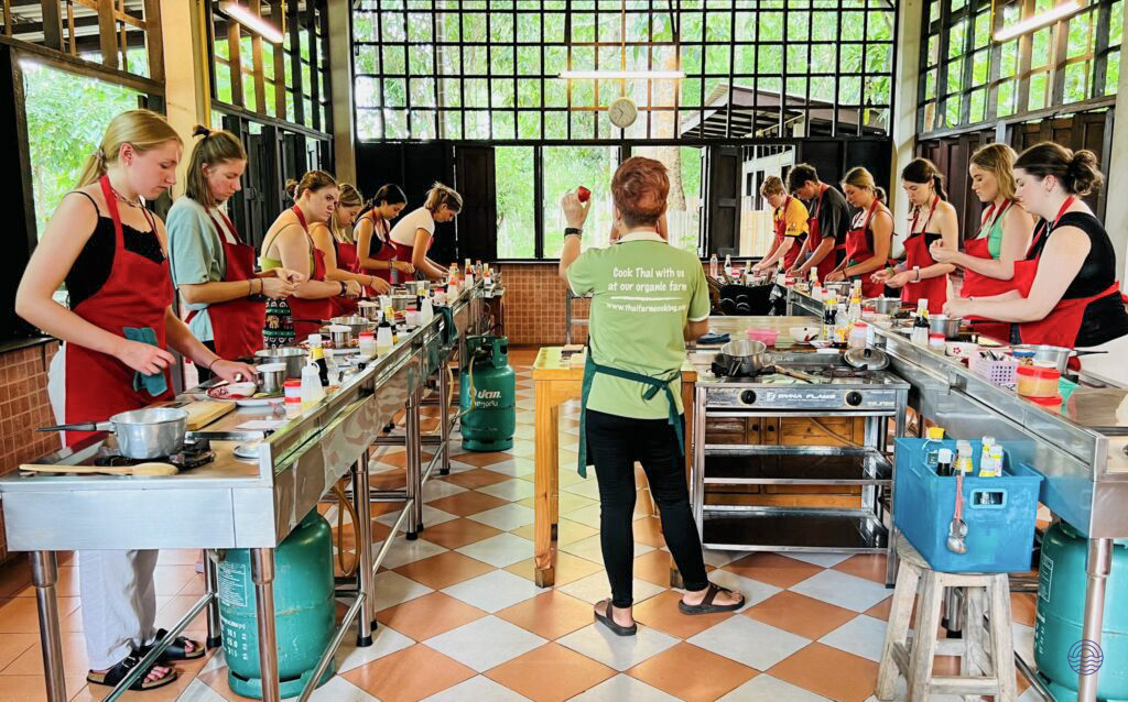 Tourists learn to cook traditional Thai dishes at a hands-on cooking class in Chiang Mai.