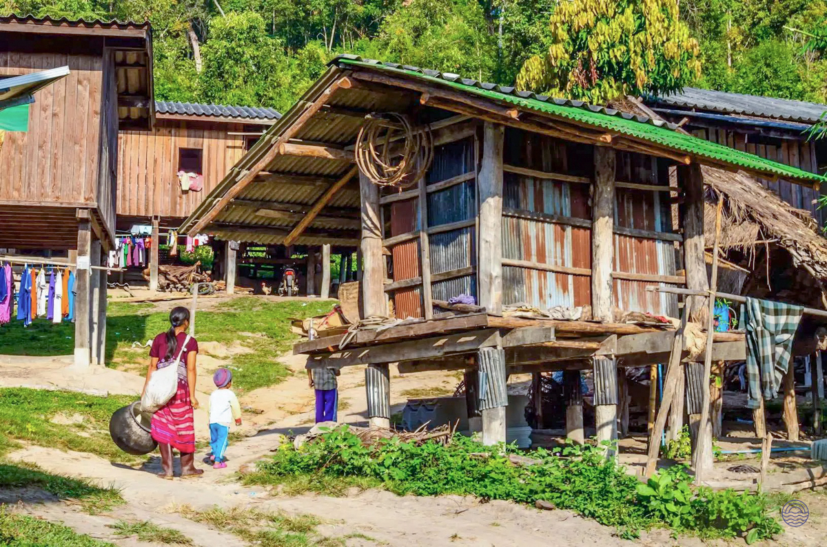A woman and child walk through a traditional Hmong village in the lush hills of Chiang Mai.