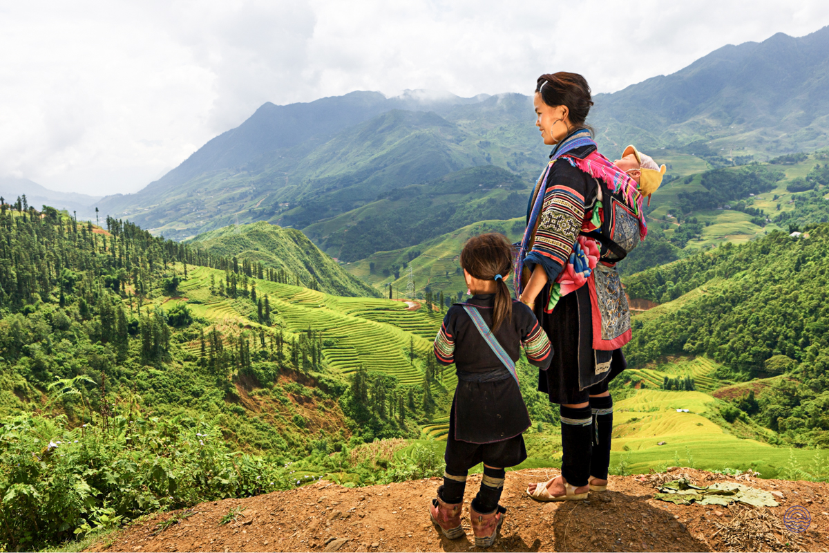 A Hmong woman and child admire the stunning terraced mountain views near Chiang Mai, Thailand.