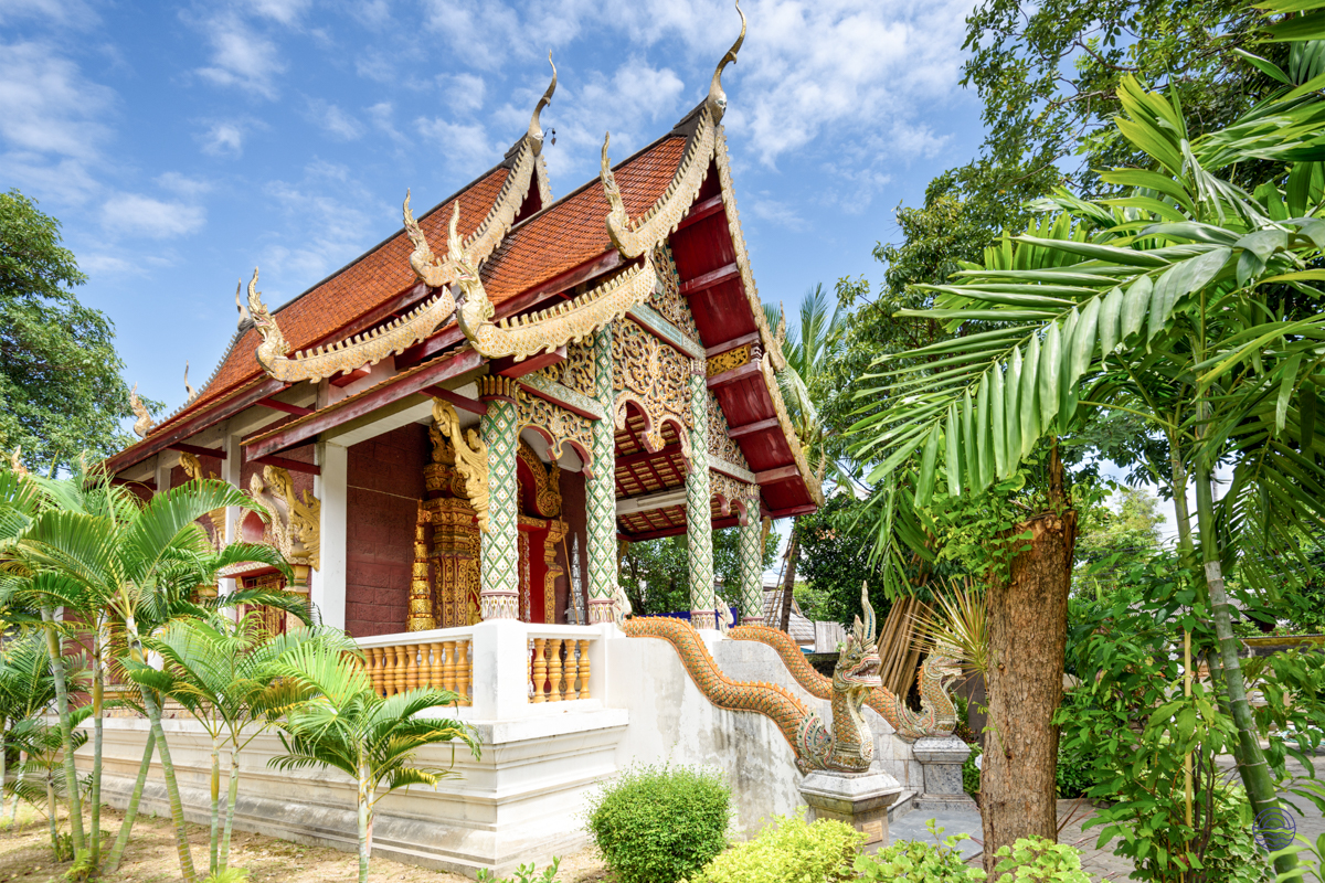 Discover the intricate beauty of a traditional Thai temple in Chiang Mai, surrounded by lush foliage.
