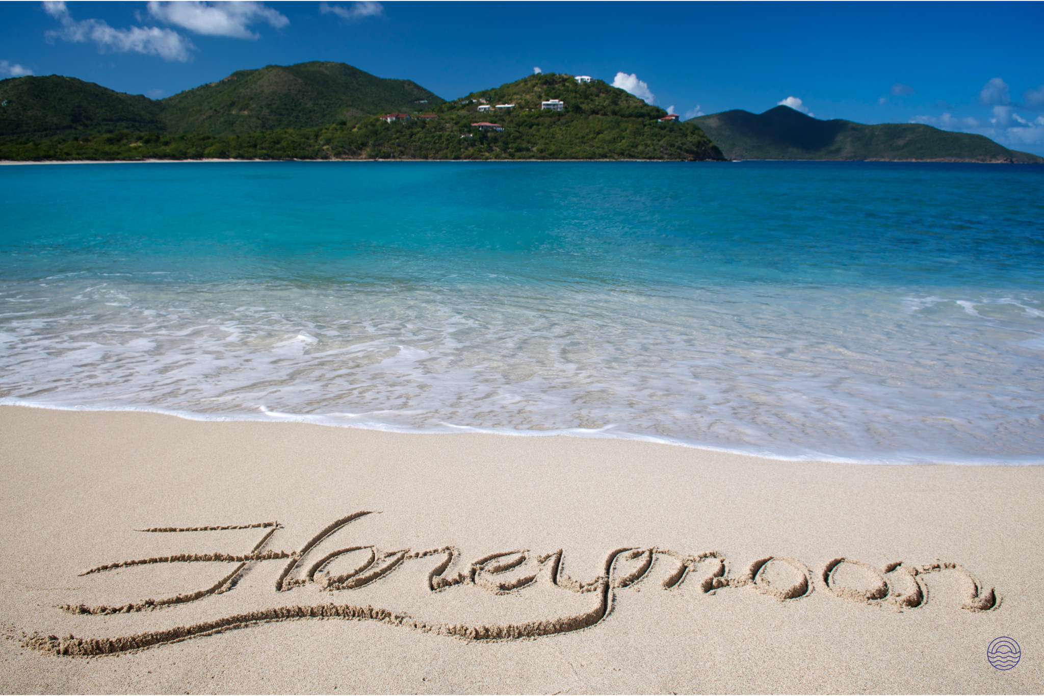 Honeymoon written in the sand on a pristine Koh Phi Phi beach with clear turquoise water.