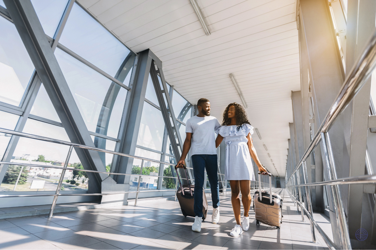 A smiling couple walking through Koh Samui airport with their luggage, ready for their flight.