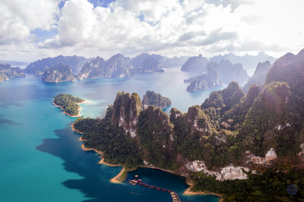 Breathtaking aerial view of Chiewlan Lake in Khao Sok, Thailand, with lush karsts and calm waters.