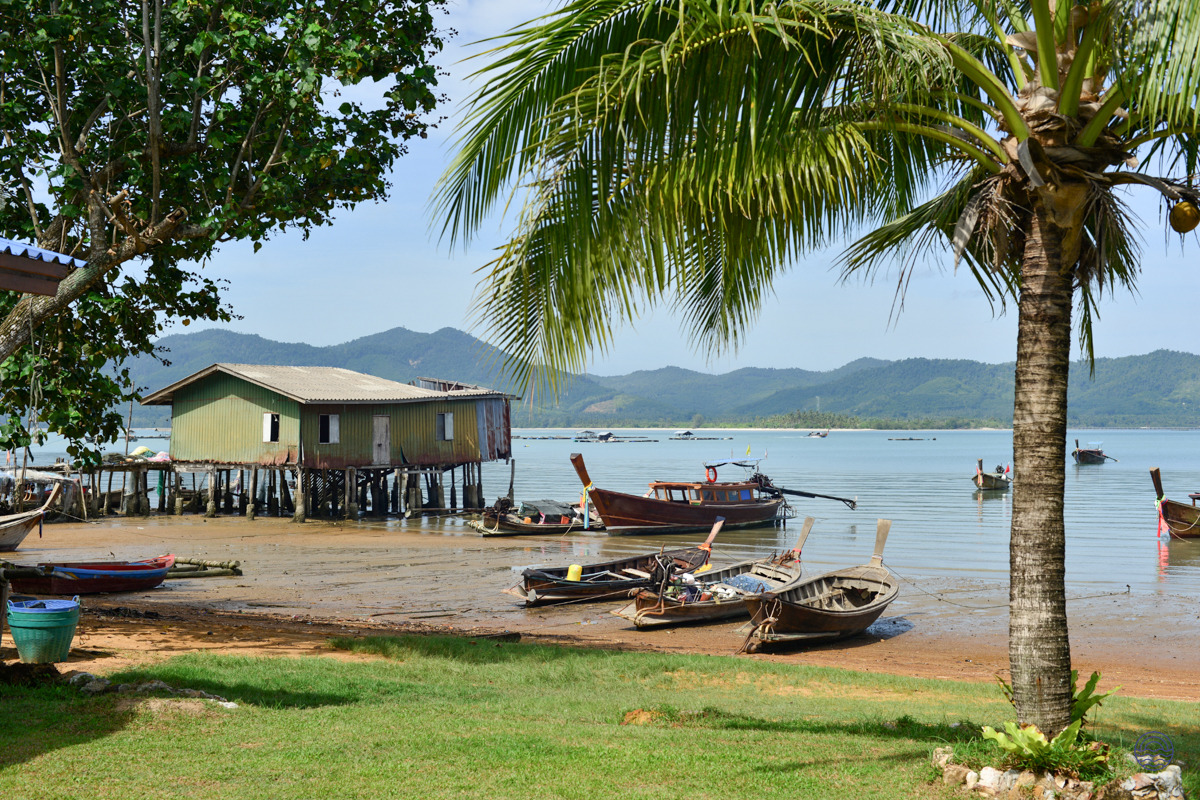 Charming fishing village scene on Koh Yao Noi, with traditional longtail boats and a stilt house.