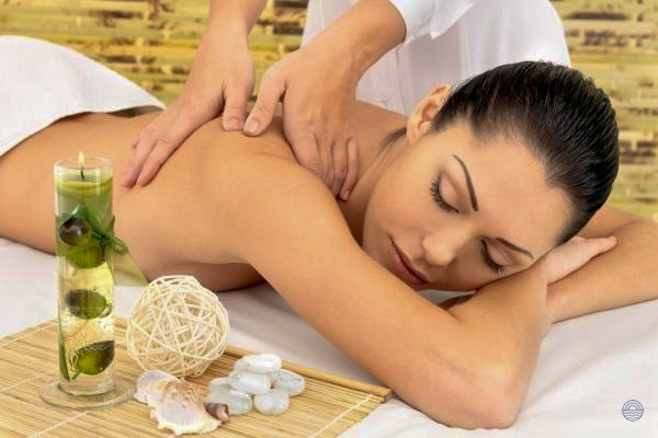 A woman enjoys a relaxing back massage at a luxurious spa in Phuket, surrounded by serene decor.