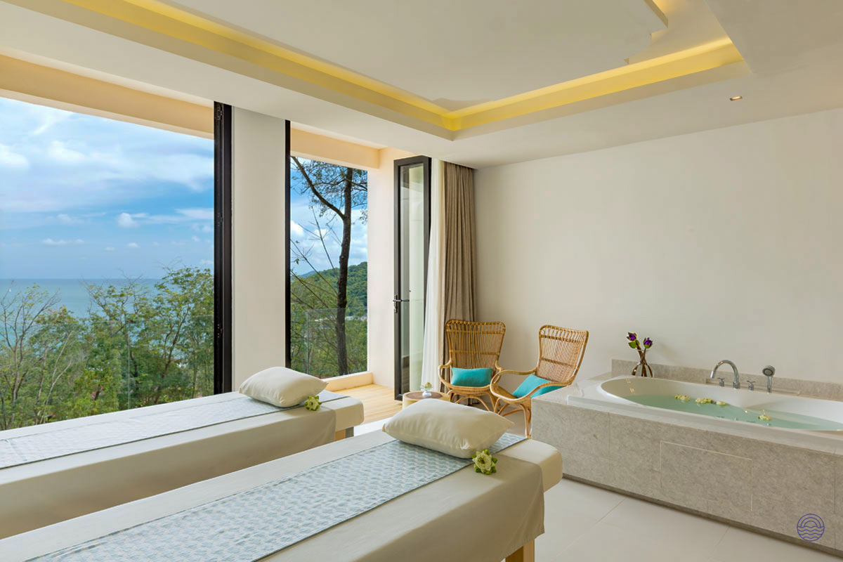 Relaxing spa room in Phuket featuring two massage beds, a large tub, and stunning ocean views.