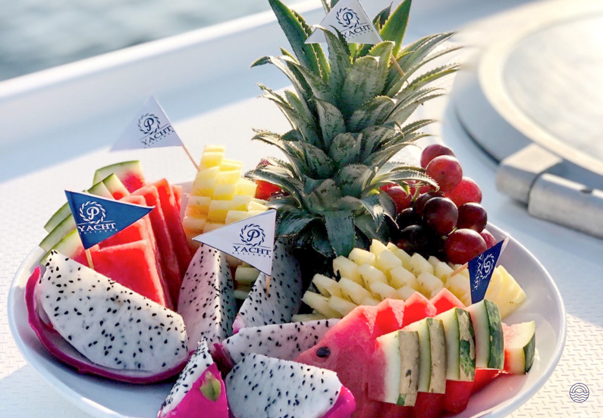 Delicious fresh tropical fruits, including pineapple, watermelon, and dragon fruit, served on a yacht.