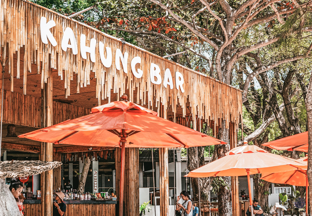 Tropical Kahung Bar with orange umbrellas and lush trees on Coral Island, Phuket.