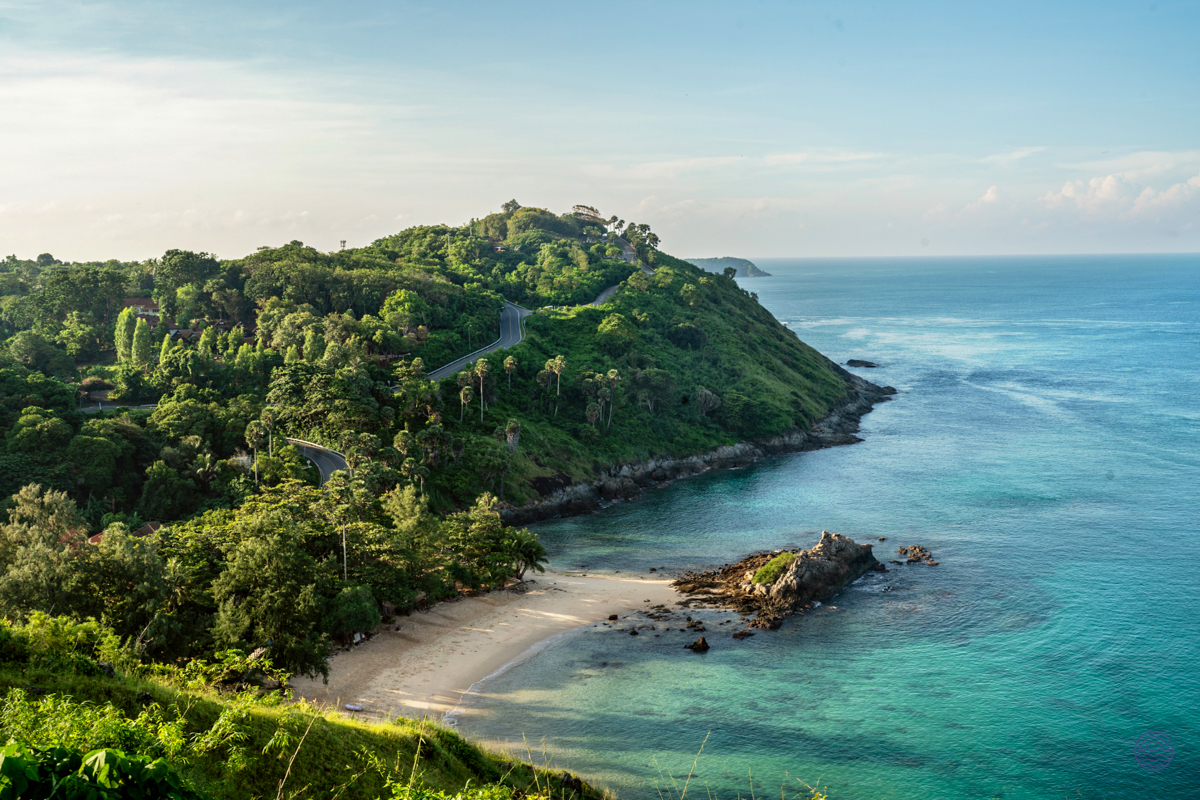 Discover the serene beauty of Phuket's coastline with lush hills and clear turquoise waters.