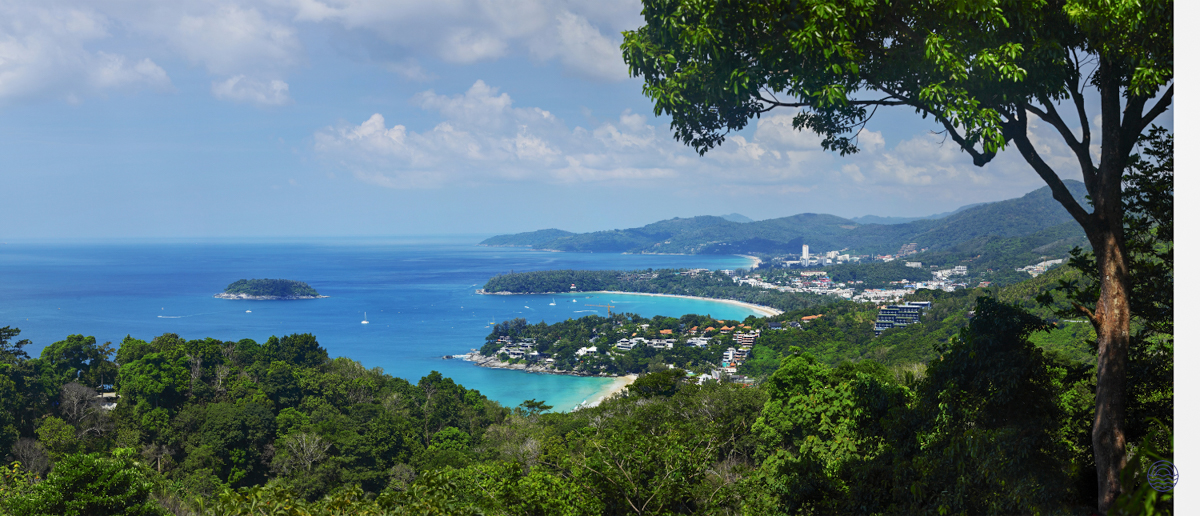 A breathtaking panoramic view of Phuket's turquoise bays, white sand beaches, and lush green hills.