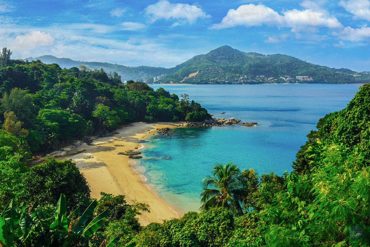 Panoramic view of a pristine tropical beach with golden sand and clear turquoise waters in Phuket.