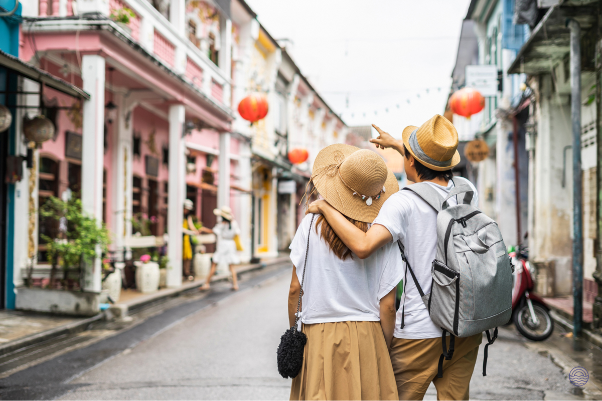 A couple explores the charming, colorful streets of Phuket Old Town, admiring the architecture.