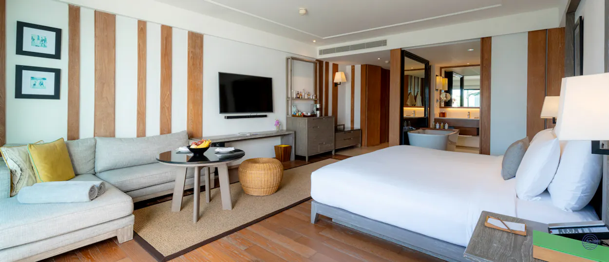Luxurious hotel room in Chiang Mai with a cozy sofa, large bed, and elegant, modern design.