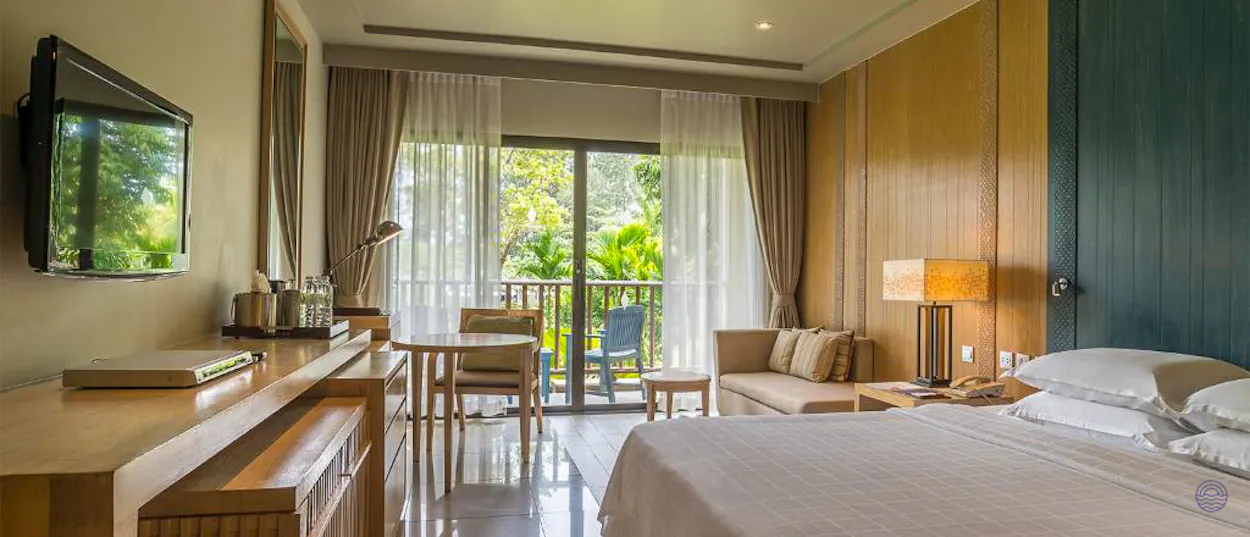 A modern hotel room in Krabi featuring a comfortable bed and a balcony with tropical views.