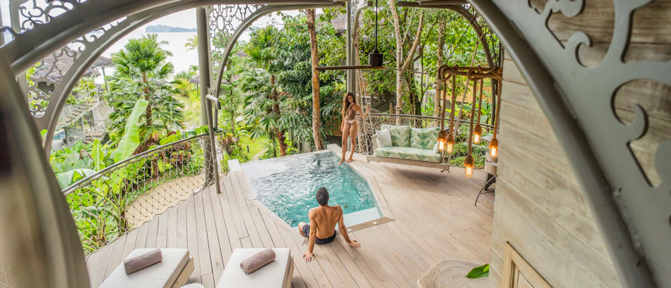 A couple enjoys a private pool on a tropical deck with ocean views at Koh Yao Noi.