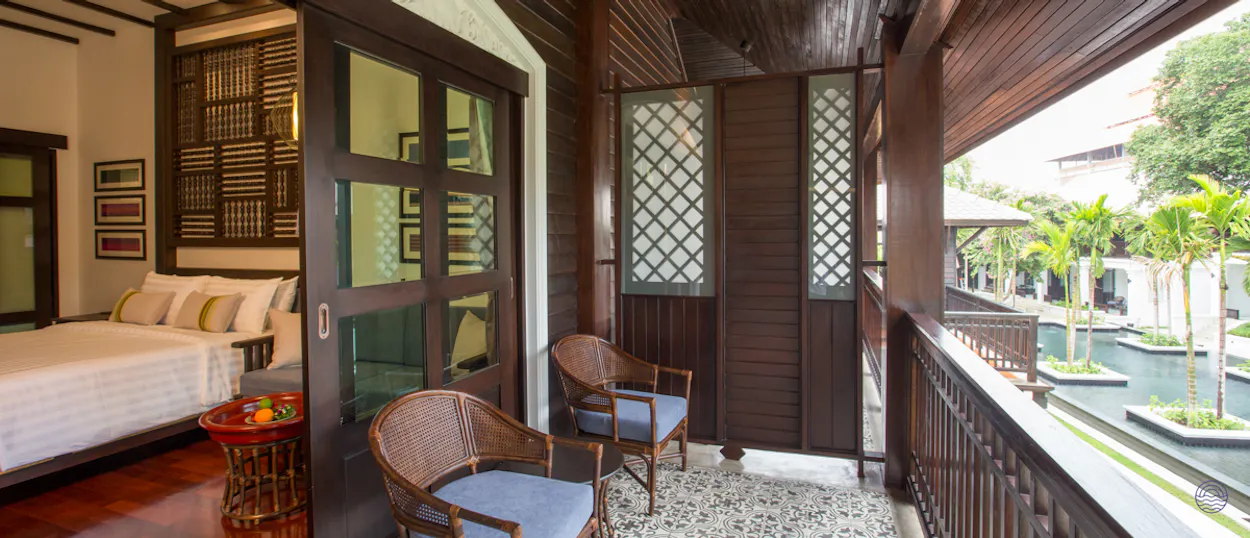 Luxurious resort room with a private balcony overlooking serene pools and tropical gardens in Chiang Mai.